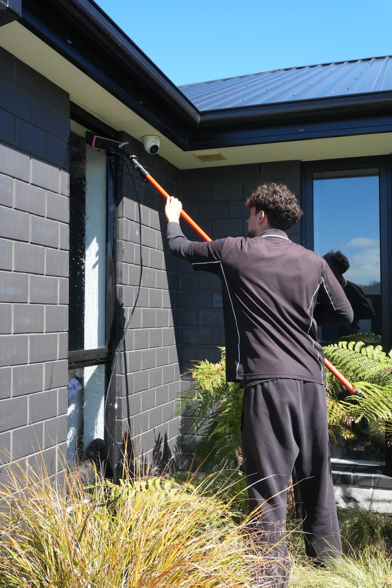 Detail work on window glass by a Never Dirty Again cleaner